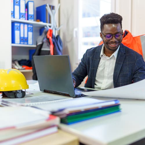 man working at computer in construction back office