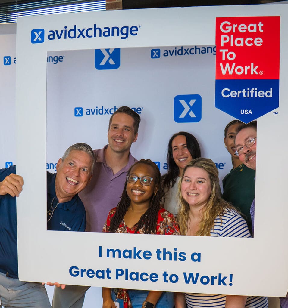 Group of smiling AvidXchange employees.