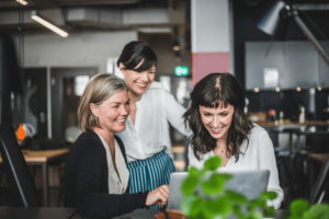 women helping each other in front of a computer at work