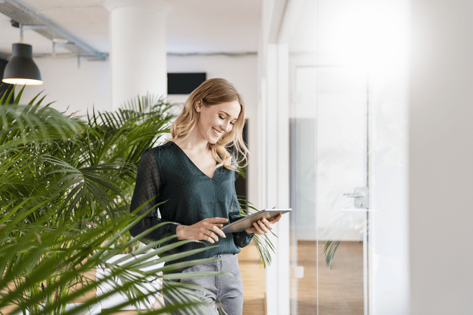 woman in an office looking at a tablet